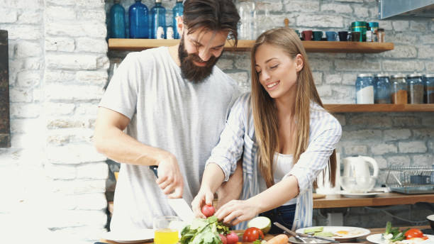 istock Young couple making dinner together at home 1180112273