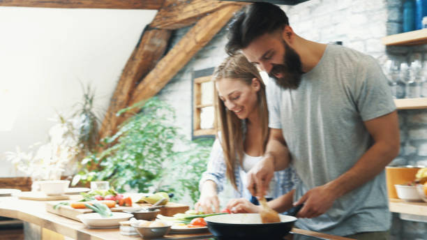 istock Young couple making dinner together at home 1180112278
