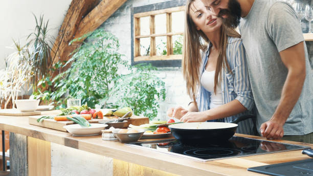 istock Young couple making dinner together at home 1180112284