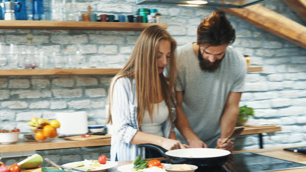 istock Young couple making dinner together at home 1180112330
