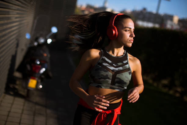 istock Young slim woman jogging in the dusk 1180112355
