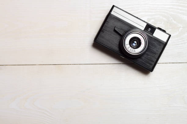 Classic film camera on white wooden background. stock photo