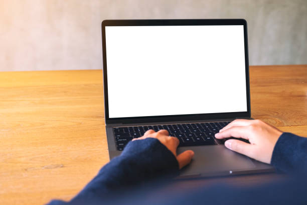 istock a woman using and typing on laptop computer keyboard with blank white desktop screen on wooden table 1180123460
