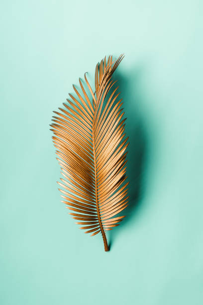 istock Tropical palm leaf painted with gold paint on delicate pastel mint background. Minimal art Concept 1180125986