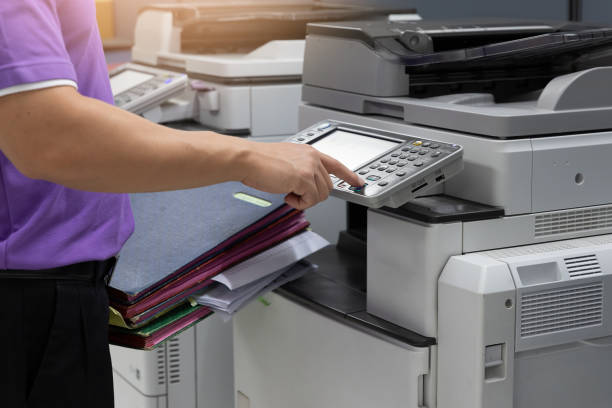 istock Bussinessman using copier machine to copy heap of paperwork in office. 1180132505