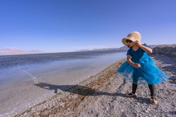 istock a young girl playing by the lake side 1180135167