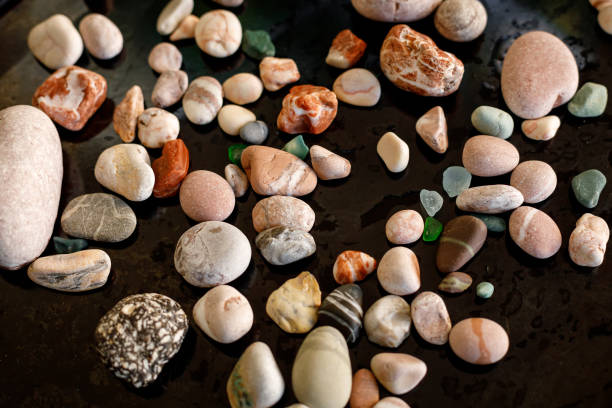 istock Collection of various colored sea pebbles on black background 1180135835