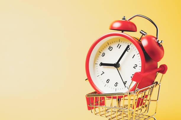 購入時間、赤いヴィンテージ目覚まし時計でクローズアップショッピングカートは黄色の背景の上に8時を示しています - 8 oclock ストックフォトと画像