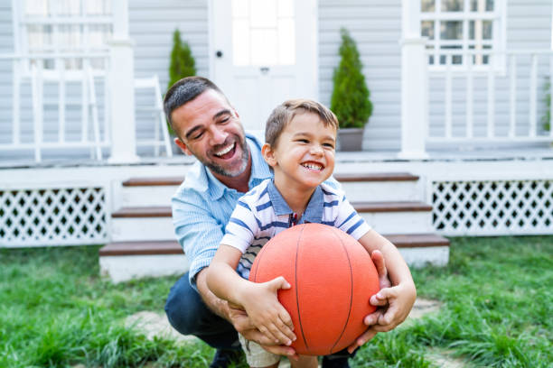 istock Father And Son Playing Basketball in front of front yard 1180140530