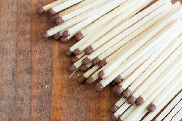 istock Wooden matches scattered on a wooden table 1180142395