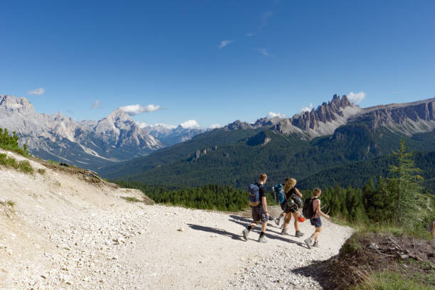 istock climbers walking down a road in a Dolomite mountain landscape after a hard climb 1180143967