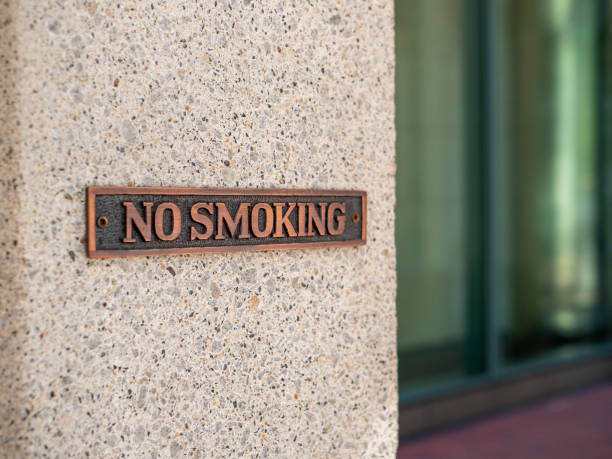 istock No smoking metal sign outside on concrete wall 1180146016