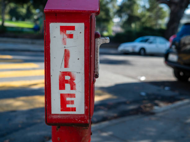 istock Outdoor fire alarm call box at urban intersection, fire in bold font 1180146266
