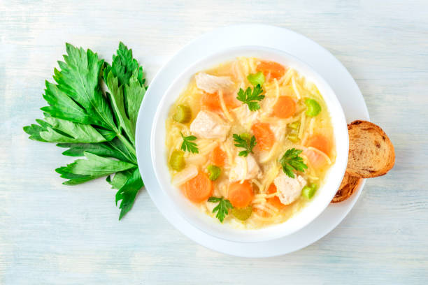 sopa de macarronete da galinha, disparado da parte superior com pão torrado - soup carrot celery chicken - fotografias e filmes do acervo