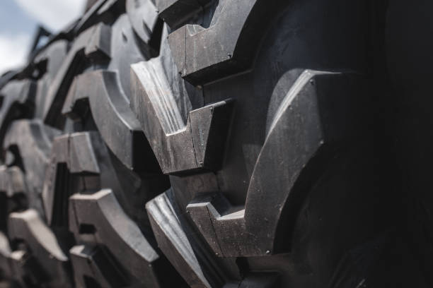 Big set of black huge big truck, tractor or bulldozer loader wheel close-up on stand, shop selling tyres for farming and big vehicles Construction machinery. Lot of pattern tread of Off-road tires. gran conjunto de camiones grandes negros, tractores o bulldozer cargador rueda primer plano en el stand, tienda de venta de neumáticos para la agricultura y vehículos grandes maquinaria de construcción. mucha banda de rodadura de patrón de neumáticos