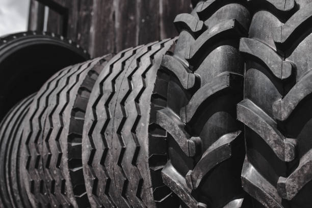 Big set of black huge big truck, tractor or bulldozer loader wheel close-up on stand, shop selling tyres for farming and big vehicles Construction machinery. Lot of pattern tread of Off-road tires. gran conjunto de camiones grandes negros, tractores o bulldozer cargador rueda primer plano en el stand, tienda de venta de neumáticos para la agricultura y vehículos grandes maquinaria de construcción. mucha banda de rodadura de patrón de neumáticos