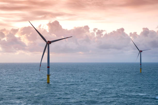 istock Sunset over offshore wind farm - green power generation 1180149543