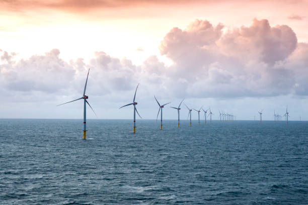 istock Sunset over offshore wind farm - green power generation 1180149594