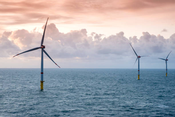 istock Sunset over offshore wind farm - green power generation 1180149632