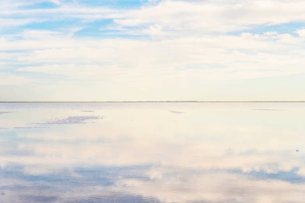 istock Sky is reflected inwater. Evening, sunset clouds reflected in lake. Background in blue, pink and orange tones. Concept of peace, relaxation, harmony. Blurred image focus. Copy space. salt lake 1180154469