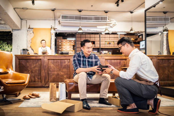 istock Salesman introducing shoes to customer 1180154537