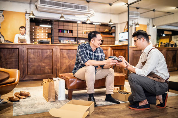 istock Salesman introducing shoes to customer 1180155106