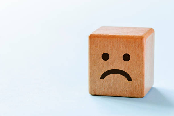 istock Small wooden dice with sad emotion 1180155549