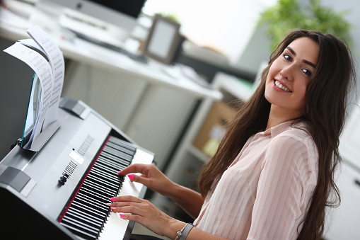 Classical music. Pretty young girl. Home studio interior. Leisure entertainment. Piano keyboard. Portrait woman. People beauty fashion. Active leisure lifestyle.