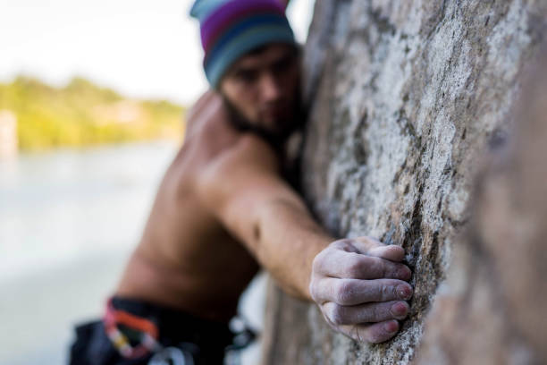 istock Portrait man cliff climber is climbing a rock. 1180161962