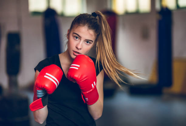 Boxing in the gym Young beautiful teenage girl boxing in the gym. fighting stance stock pictures, royalty-free photos & images