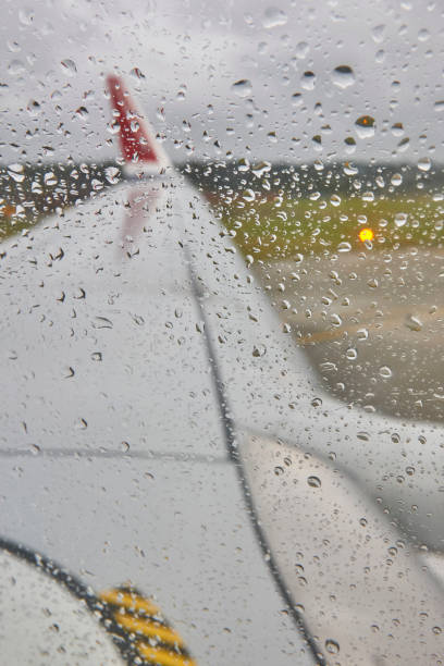 Airplane window on a rainy day in the runaway. Transportation