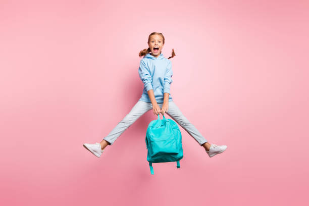 sommer! full-size-foto von hübschen kleinen dame springen hoch genießen letzten studium tag tragen petrol schüler rucksack lässig pullover kleidung isoliert rosa farbe hintergrund - child bizarre little girls humor stock-fotos und bilder