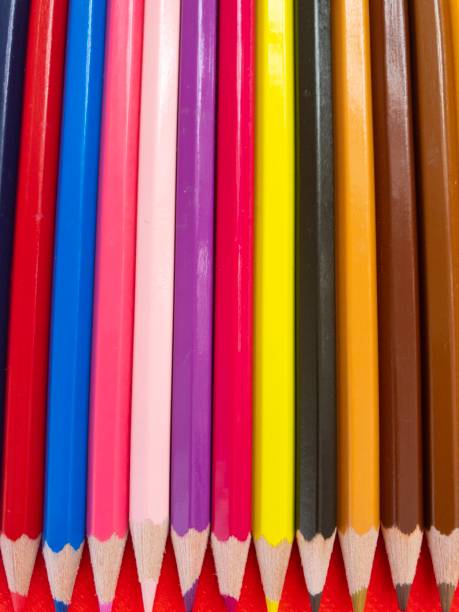istock Colored paint pencils on red background 1180166135