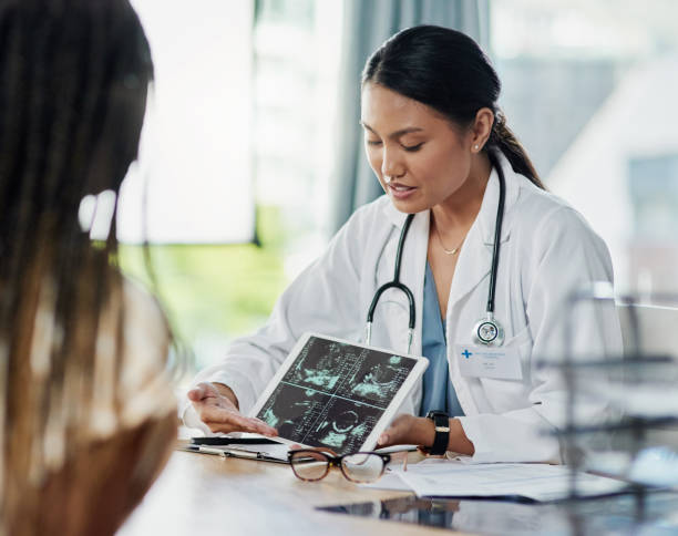 Your baby is in perfect health Closeup shot of a doctor showing a patient ultrasound scans on a digital tablet in her office obstetrician asian stock pictures, royalty-free photos & images