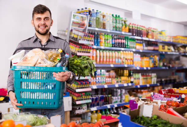 istock guy standing with full shopping basket 1180168127