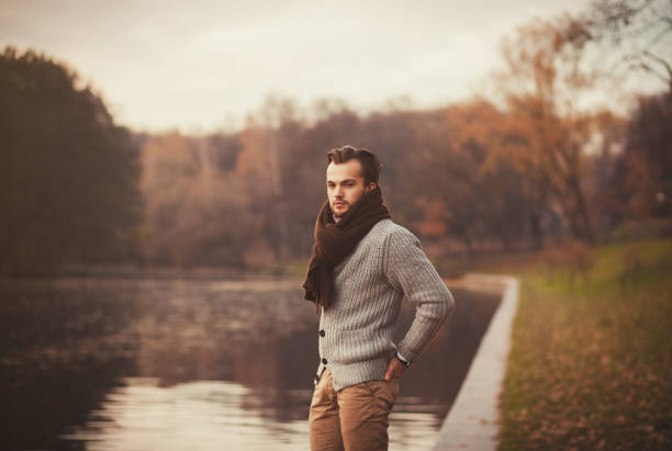 istock young man posing in the autumn park 1180168162