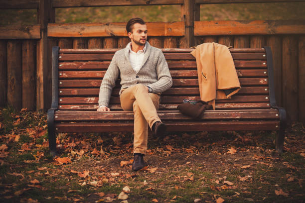 istock Handsome young man sitting on the bench 1180168200