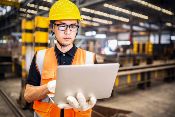 asiatischer ingenieur mit einem laptop in einer fabrik - construction worker hardhat safety manual worker stock-fotos und bilder