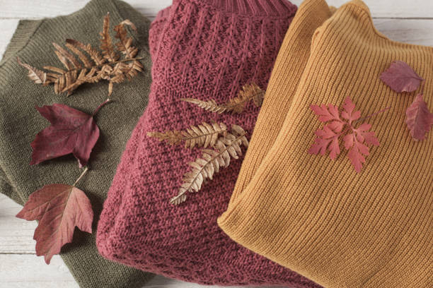 istock stack of sweaters with autumn leaves  on  white wooden table 1180171064