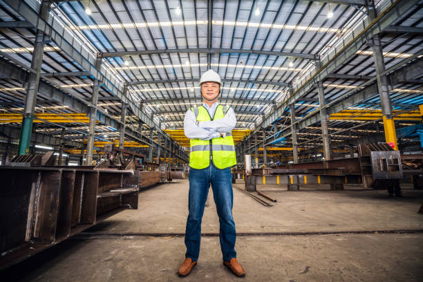 Confident Asian engineer in a steel factory