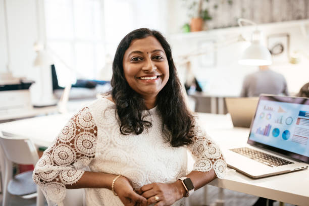 Indian businesswoman working in office on laptop, dealing with charts and finances Multi-ethnic teamwork in coworking office scandinavian descent photos stock pictures, royalty-free photos & images