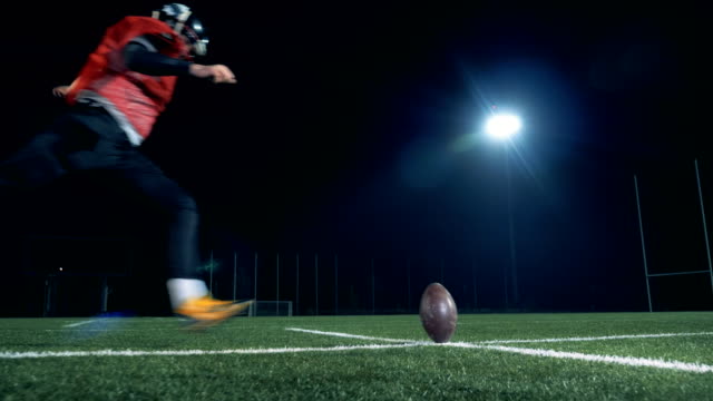 American football player scoring a goal, back view.