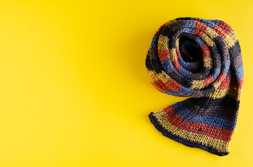 Woolen scarf composition on yellow background. Flat lay, layout and tabletop mockup with copy space.