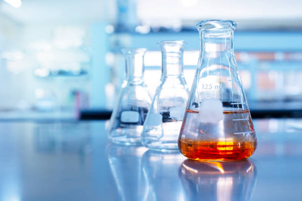 istock orange solution in science glass flask in blue chemistry school laboratory background 1180177234