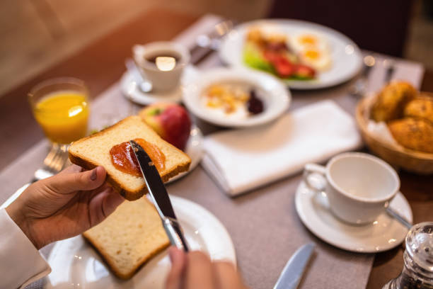 istock Young woman spreading jam on a toast 1180179991