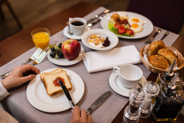 istock Young woman spreading jam on a toast 1180181472