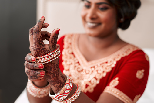 Cropped shot of a beautiful young bride putting on her bracelets in preparation for her wedding