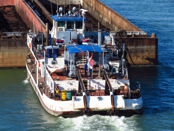istock Top view of Tugboat pushing a empty barge on the river 1180183114