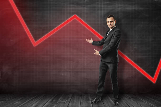 istock Young businessman making presenting gesture at red graphic polygonal curve behind him. 1180187907