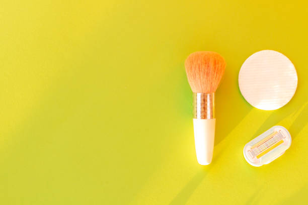 istock Brush for applying blush and cotton sponge discs with removable razor cartridge on a light green background in the sun with space for text. Creative idea for beauty products and make-up. Flat lay. 1180190479